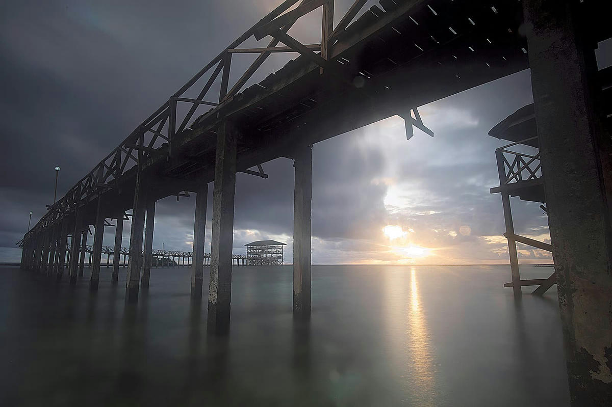 Sunrise seen from under the Cloud 9 boardwalk at low tide