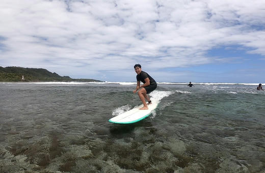A surfer riding a wave off Siargao