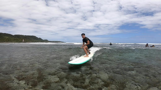A surfer riding a wave off Siargao