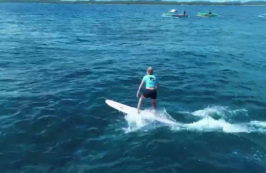 A longboarder noseriding a small clean wave at Jacking Horse, General Luna, Siargao