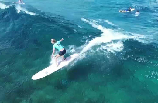 A surfer trimming along a clean wave face at Siargao